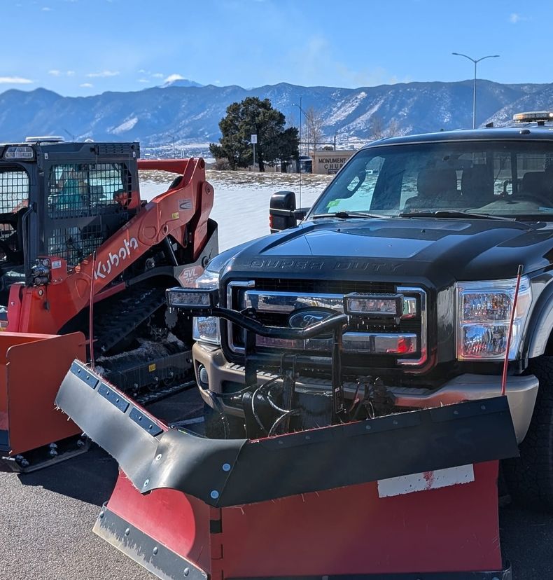 Red Beard's loader and plow truck with the mountains behind