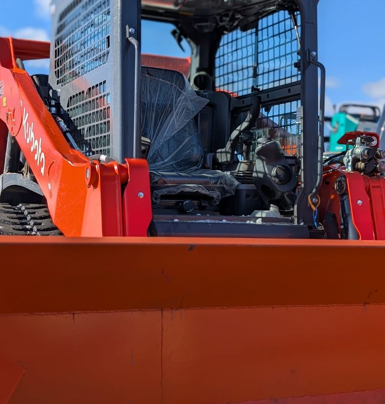 Kubota track loader with orange snow pusher