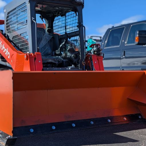 Kubota track loader with an orange snow pusher
